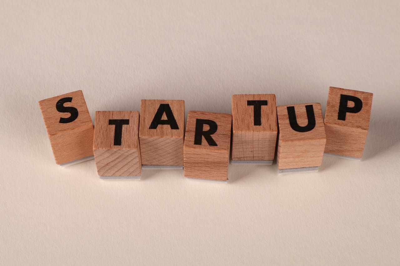 Wooden blocks forming the word STARTUP on a neutral background, symbolizing new business ventures.